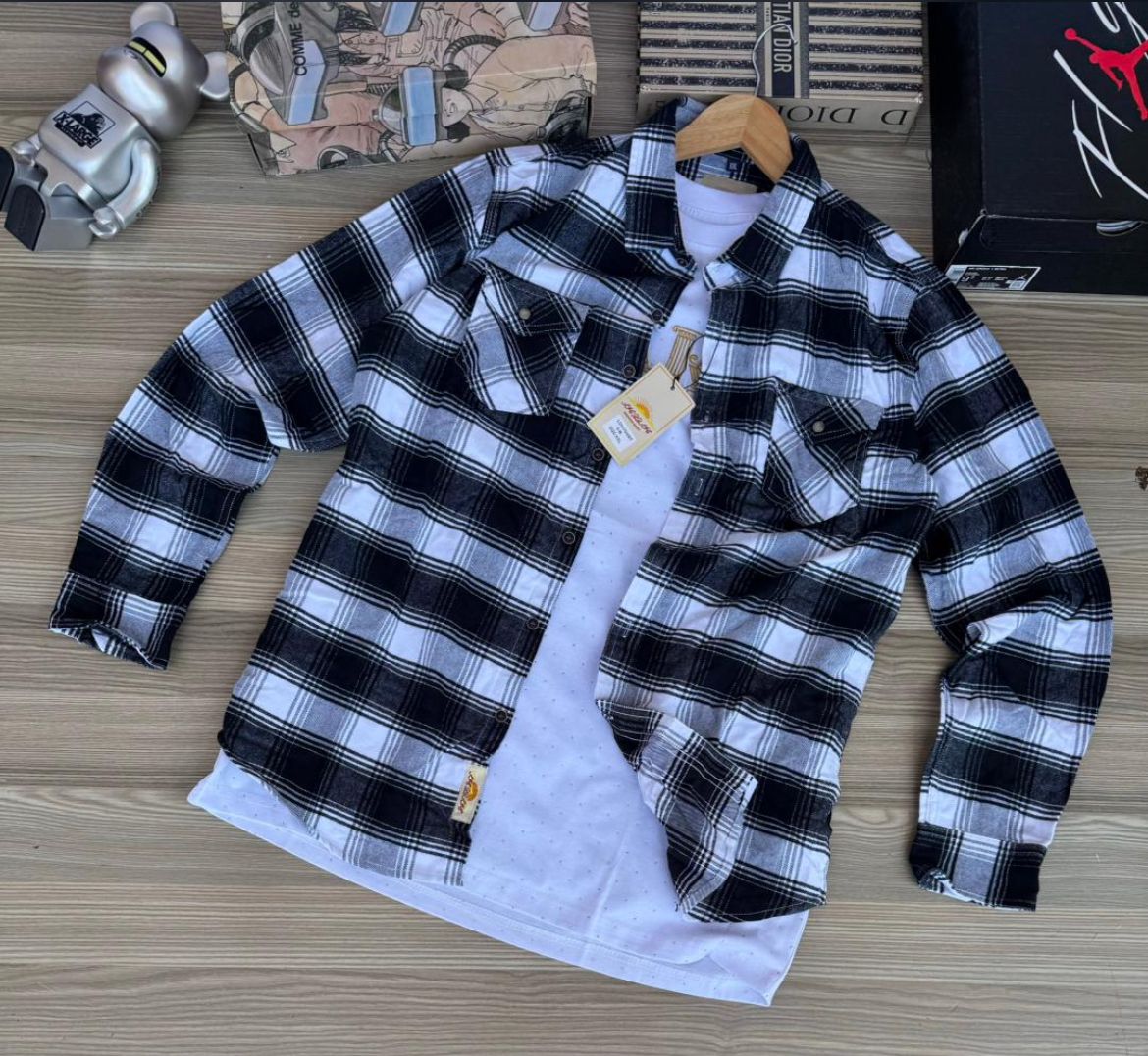 Black and white plaid flannel shirt with button-up front, two chest pockets, and a white t-shirt layered underneath