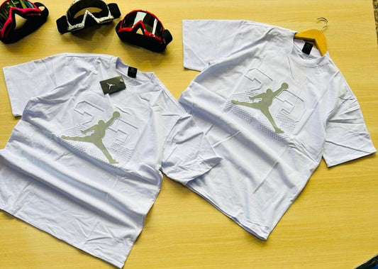 A white Jordan t-shirt featuring the iconic Jumpman silhouette and the number 23 in a stylish graphic design.